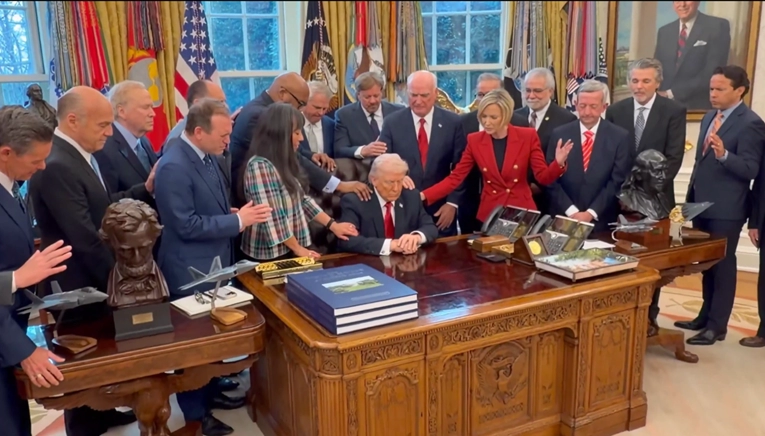 Ovo je snimka iz Bijele kuće. Vjerske vođe drže ruke na Trumpu i mole za njega